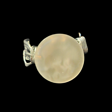 A handmade button ring on a dark background